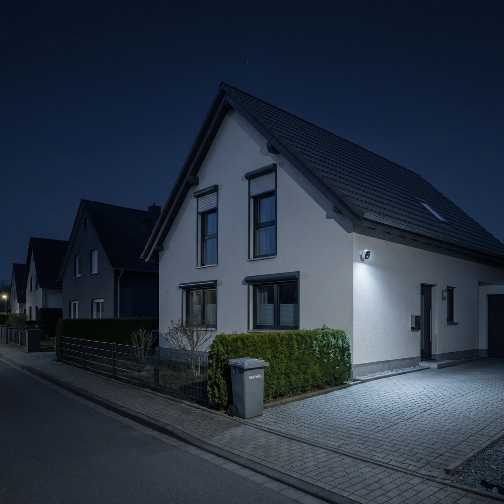 Dunkle Wohnstrasse bei Nacht, nur ein Haus ist vom Scheinwerfer der GuardCam Pro beleuchtet